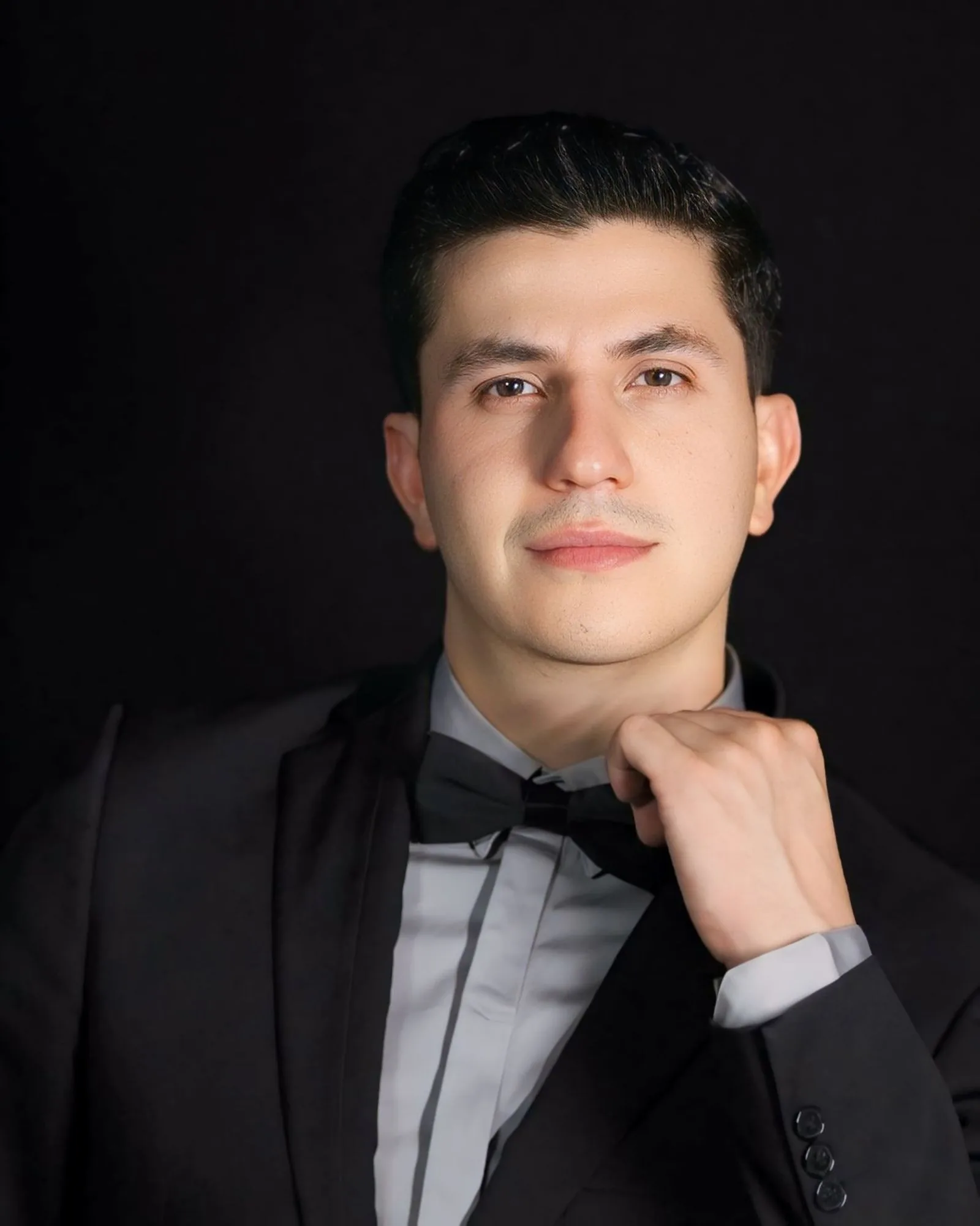 Caballero con esmoquin negro y corbatín para una gala formal