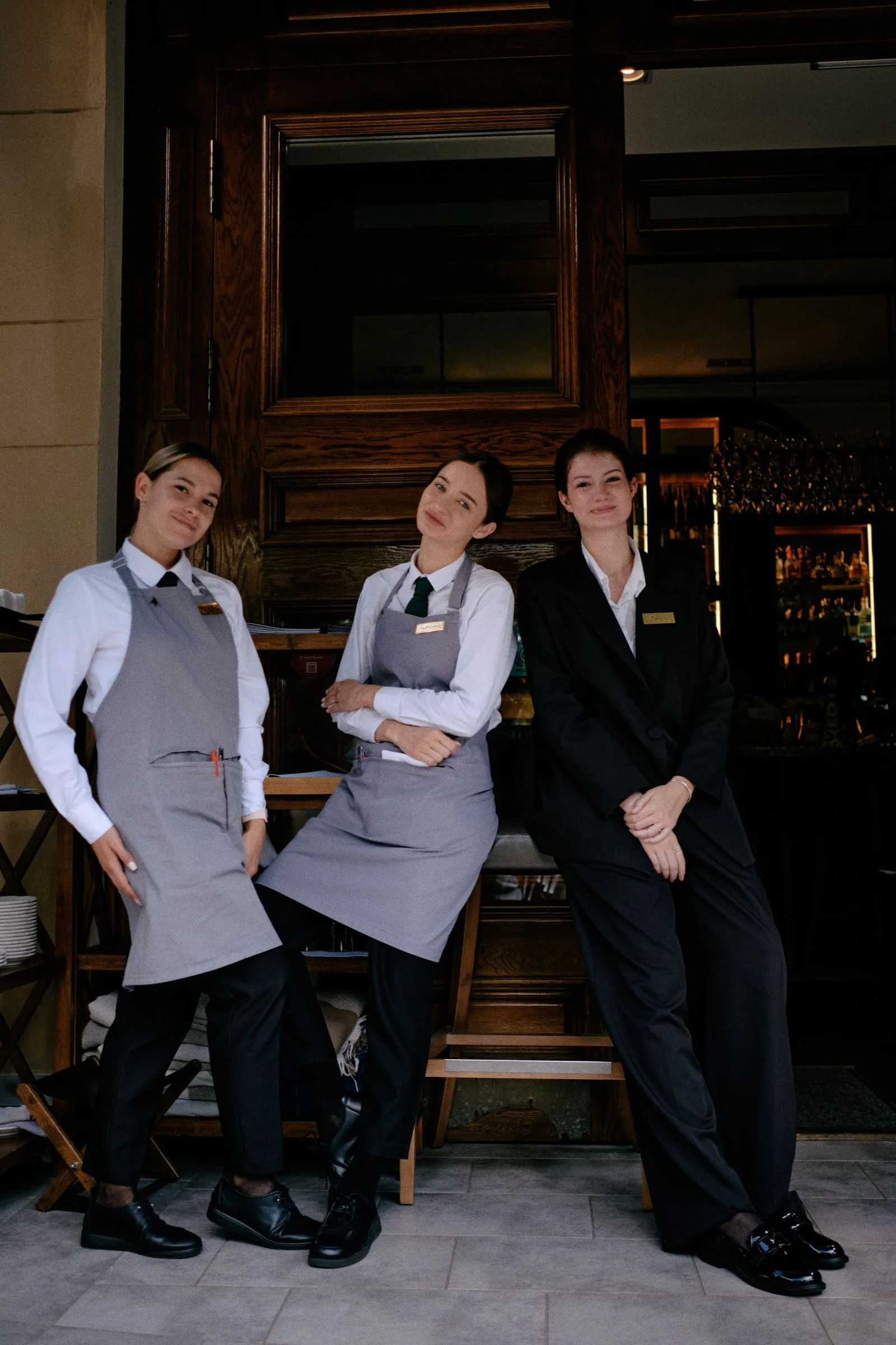 Personal de restaurante con uniformes elegantes de atención y hospitalidad